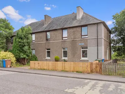 a brown brick house with a wooden fence at Whiteside 3 Bedroom Apartment - Bathgate in Bathgate