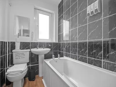 a bathroom with a toilet and a sink and a tub at Mollison 2 Bedroom Apartment - Harthill in Harthill