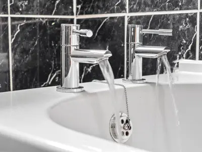 a bathroom sink with water running from two faucets at Mollison 2 Bedroom Apartment - Harthill in Harthill