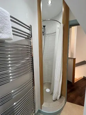 a shower with a glass door in a bathroom at Retreat to the Water Tower in Queensferry