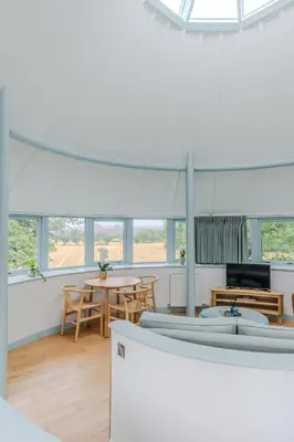 a white room with a table and chairs and windows at Retreat to the Water Tower in Queensferry