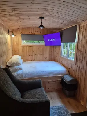 a bedroom with a bed and a couch in a room at Blair snug hut 2 in Kelty