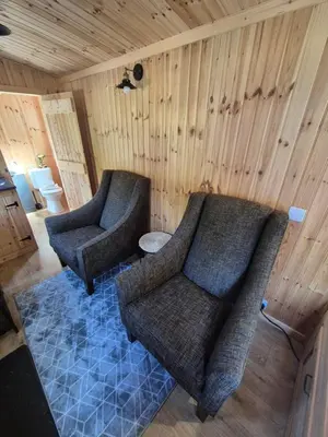 a living room with two chairs and a couch at Blair snug hut 2 in Kelty
