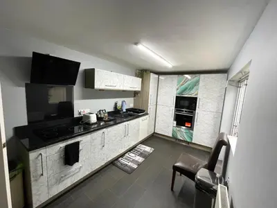 a kitchen with white cabinets and a black counter top at Cosy 2 Bed Apartment in Crossford near Lanark in Crossford