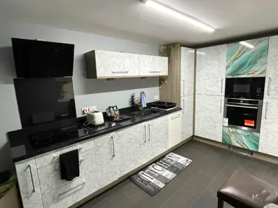 a kitchen with white cabinets and a black counter top at Cosy 2 Bed Apartment in Crossford near Lanark in Crossford