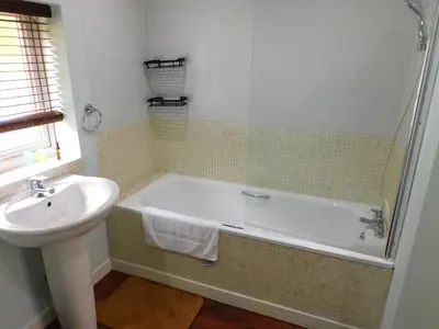 a bathroom with a bath tub and a sink at Cosy 2 Bed Apartment in Crossford near Lanark in Crossford