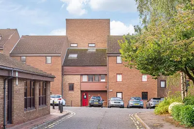 a row of brick houses with cars parked in the driveway at City Centre Apartment in Dunfermline