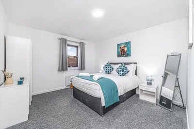 a bedroom with a bed and a mirror in it at City Centre Apartment in Dunfermline