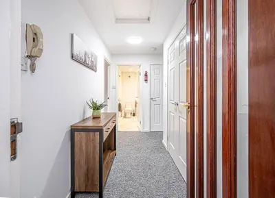 a hallway with a wooden desk in a room at City Centre Apartment in Dunfermline