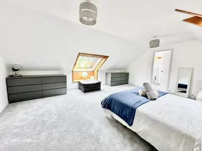 a white bedroom with a bed and a window at Avenue Cottage, Inveraray in Inveraray