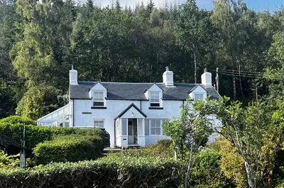 a white house sitting on top of a hill at Old Schoolhouse in Inveraray