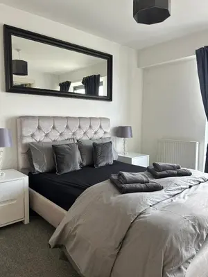 a bedroom with a large bed with a large mirror at Waterfront Spacious Flat in Edinburgh