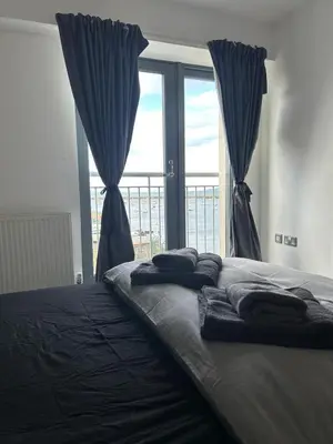 a bed with towels on it in a room with a window at Waterfront Spacious Flat in Edinburgh