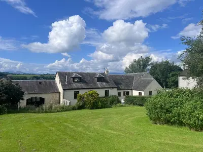 a large white house with a green yard at Easter Auchencarroch Farm B&B in Balloch