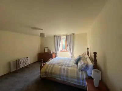 a bedroom with a bed and a window at Easter Auchencarroch Farm B&B in Balloch