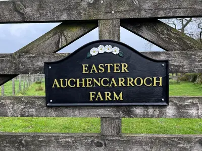 a sign on top of a wooden fence at Easter Auchencarroch Farm B&B in Balloch