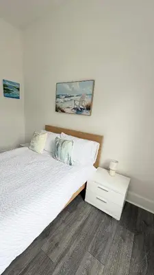a bedroom with a large bed with a night stand at Seaview apartment in Rothesay in Rothesay