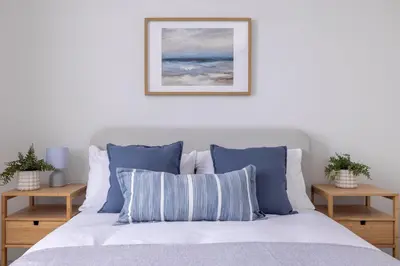 a bedroom with a bed with blue and white pillows at Antonine Quarters in Grahamston