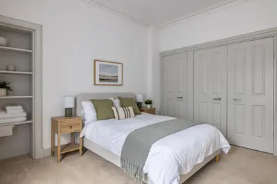 a white bedroom with a bed and a closet at Antonine Quarters in Grahamston