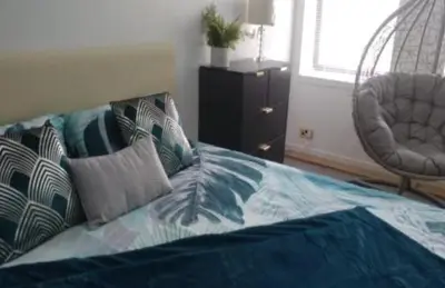 a bedroom with a bed with pillows on it at gourock blissful apartment with 3 bedrooms in Gourock