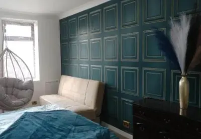 a bedroom with a couch and a chair next to a bed at gourock blissful apartment with 3 bedrooms in Gourock