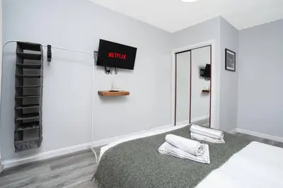 a white room with a bed and a clock on the wall at Wardlaw Retreat-WiFi-Parking in Oakley