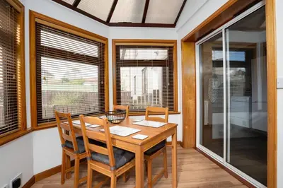 a dining room with a table and chairs and windows at Wardlaw Retreat-WiFi-Parking in Oakley