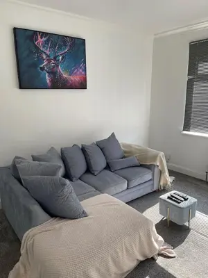 a living room with a couch and a painting on the wall at Glasgow City Apartment with 2 Bedrooms in Glasgow
