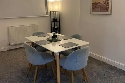 a table with four chairs and a table with a laptop at Glasgow City Apartment with 2 Bedrooms in Glasgow