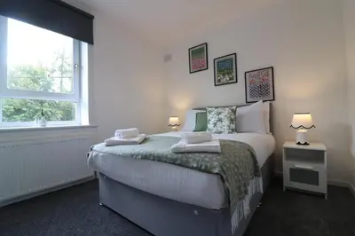 a bedroom with a bed with two towels on it at Signature - Hattrix View in Cumbernauld