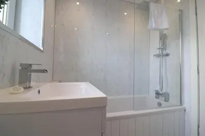 a white bathroom with a sink and a tub at Signature - Hattrix View in Cumbernauld