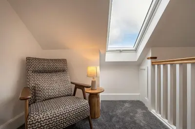 a room with a chair and a window at Strathfillan Lodge in Crianlarich