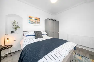 a bedroom with a large bed in a white room at Couples or Golfers Near to Beach in Troon