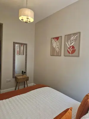 a bedroom with a bed and a mirror at City Residence Free Parking in Stirling