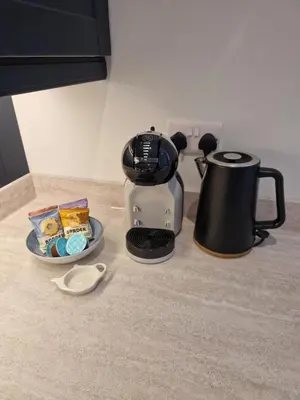 a coffee maker and a plate of food on a counter at City Residence Free Parking in Stirling