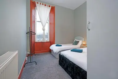 a bedroom with two beds and a window at Family and Group Stay 2BR by Park Sleeps 7 in Glasgow