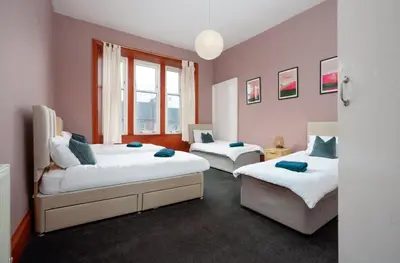 a bedroom with two beds and a window at Family and Group Stay 2BR by Park Sleeps 7 in Glasgow