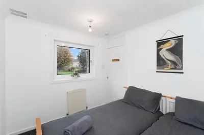 a living room with a couch and a window at 3BR Family House with Free Parking in West Lothian in Whitburn