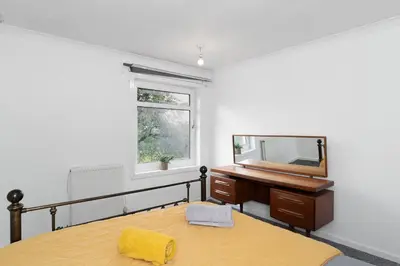 a bedroom with a bed and a mirror and a desk at 3BR Family House with Free Parking in West Lothian in Whitburn
