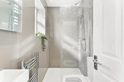 a white bathroom with a shower and a toilet at Modern 2-Bed Apartment in Canterbury City Centre in Moffat