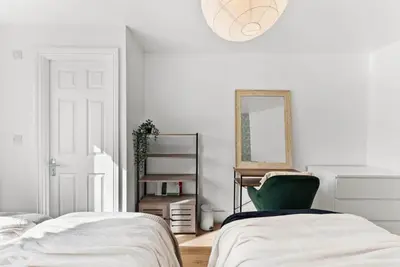 a bedroom with a green chair and a mirror at Modern 2-Bed Apartment in Canterbury City Centre in Moffat