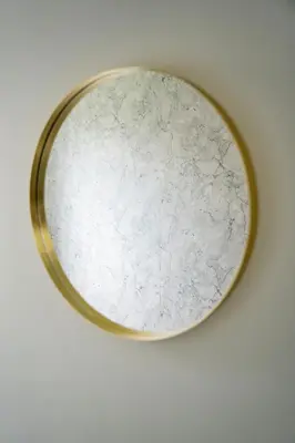 a round mirror hanging on a wall at JustStay Glasgow - 3 Bedroom Luxury Villa with free parking in Bailleston