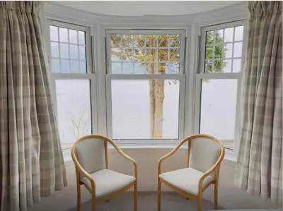 two chairs sitting in front of a window at Camus House, Lochside Guest House in Onich