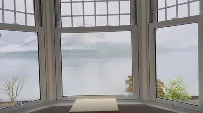 a room with three windows looking out at the water at Camus House, Lochside Guest House in Onich