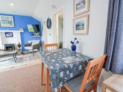 a dining room with a table and a living room at Learig Lodge in Girvan