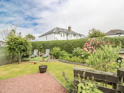 a garden in front of a white house at Learig Lodge in Girvan