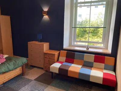 a bedroom with a bed and a window at The Tartan Sheep in Kilmarnock