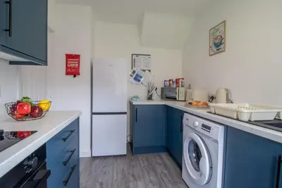 a kitchen with a washing machine and a refrigerator at Gray House-Modern 2BR close to Loch Lomond in Alexandria