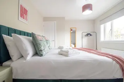 a bedroom with a white bed with white pillows at Gray House-Modern 2BR close to Loch Lomond in Alexandria