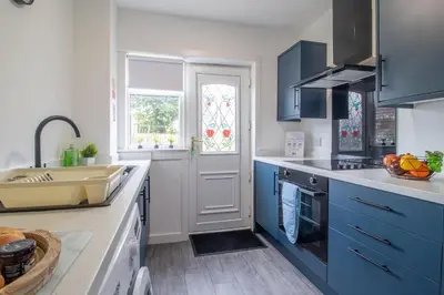 a kitchen with blue cabinets and a sink at Gray House-Modern 2BR close to Loch Lomond in Alexandria